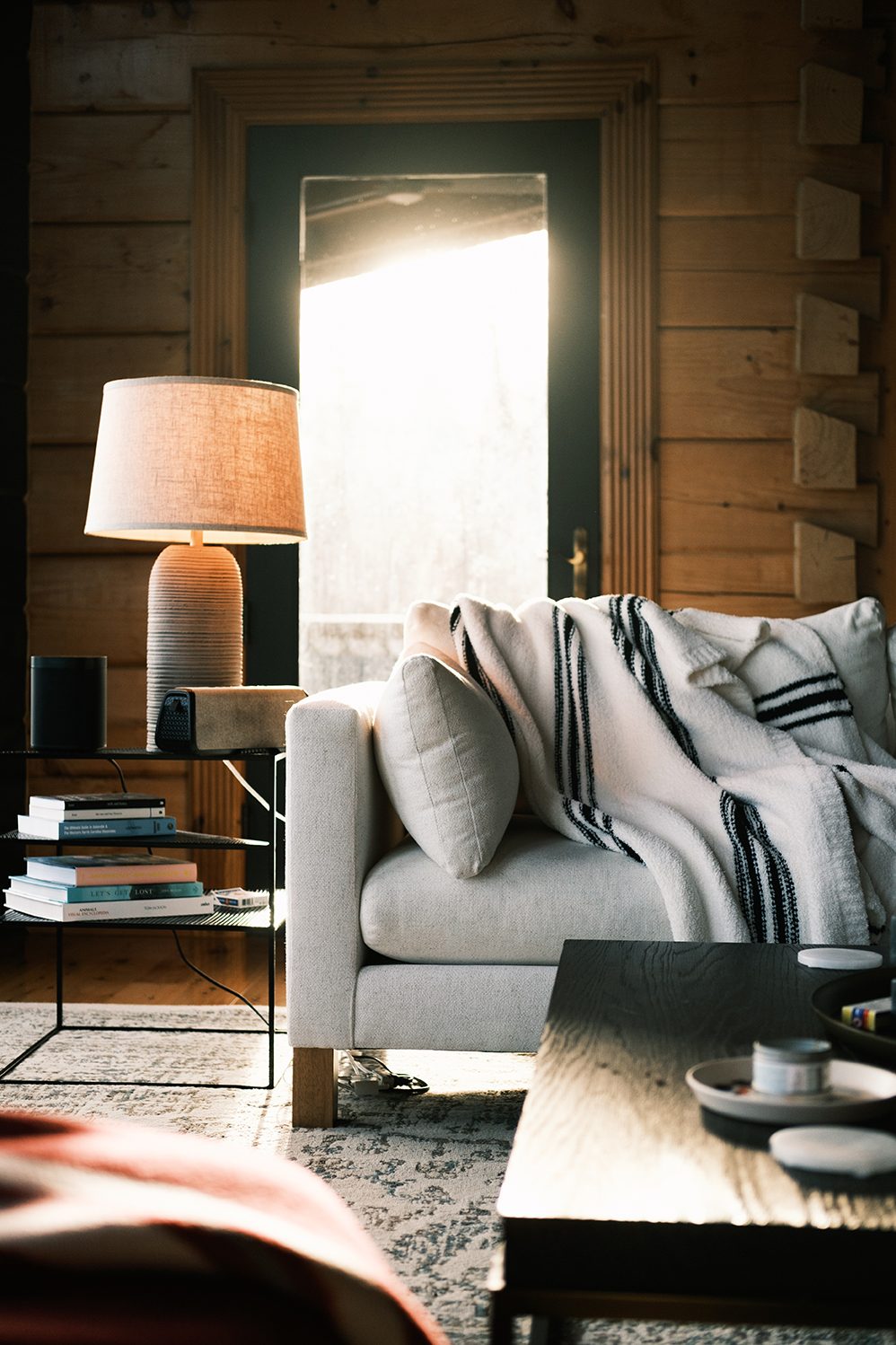 Warm lamplight over a striped throw