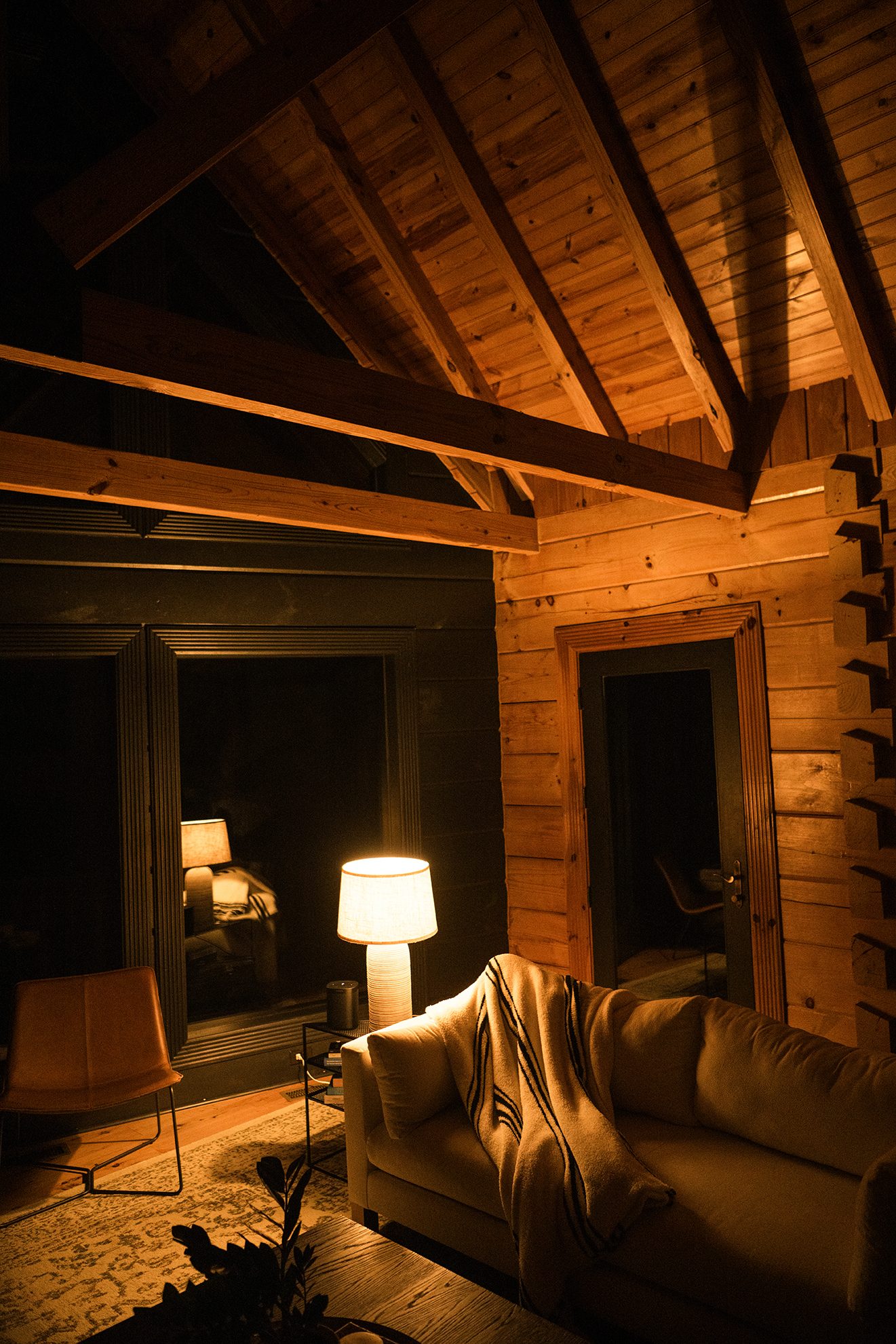 The cabin settling in for the night, lamps low