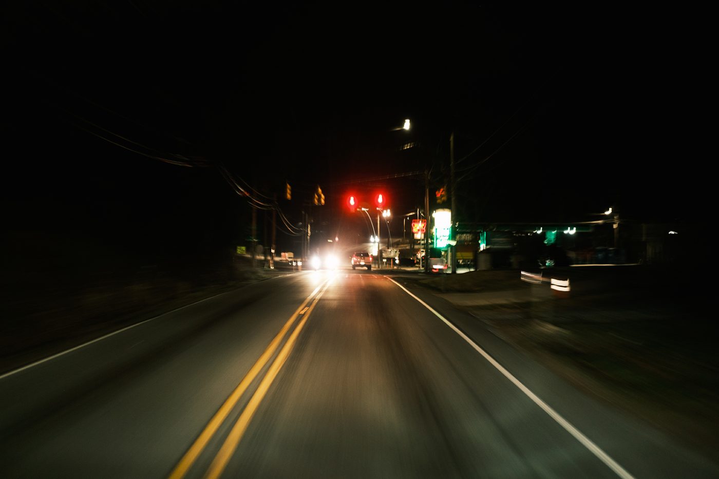 Headlights on a dark mountain road at night